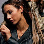 Model wearing The Raw One Dalmatian Necklace by Märta Larsson with leather jacket and layered earrings. Dalmatian stone necklace styled for confident fashion and expressive edge.