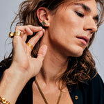 Model wearing Mondrian Stud Earrings Dalmatian by Märta Larsson with lightning bolt ear cuff. Dalmatian stone earrings styled for expressive fashion and geometric balance.