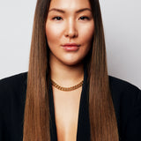 Brunette woman with long hair wearing a black blazer and Märta Larsson gold collar necklace.
