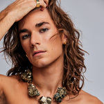 Model wearing Iggy Stud Earrings Gold Vermeil by Märta Larsson with bare shoulders and translucent crystal necklace. Gold studs styled for natural elegance and rock-inspired minimalism.