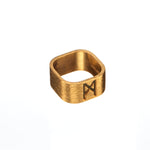 Product image of the Signature Brushed Gold Ring by Märta Larsson, displayed against a white background. The ring features a 10 mm wide band in 24 carat brushed gold vermeil on recycled 925 sterling silver. Its matte finish and engraved Märta Larsson logo give it a minimal yet powerful presence — a modern signature piece designed to leave its mark.