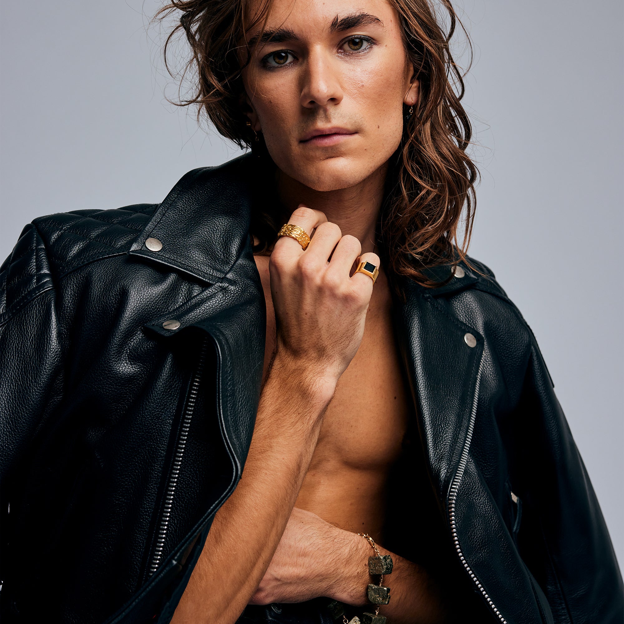 Male model wearing the Black Tourmaline Ring by Märta Larsson in gold vermeil, styled with a leather jacket. This brushed gold ring with black tourmaline evokes rock & roll elegance and Swedish design craftsmanship.