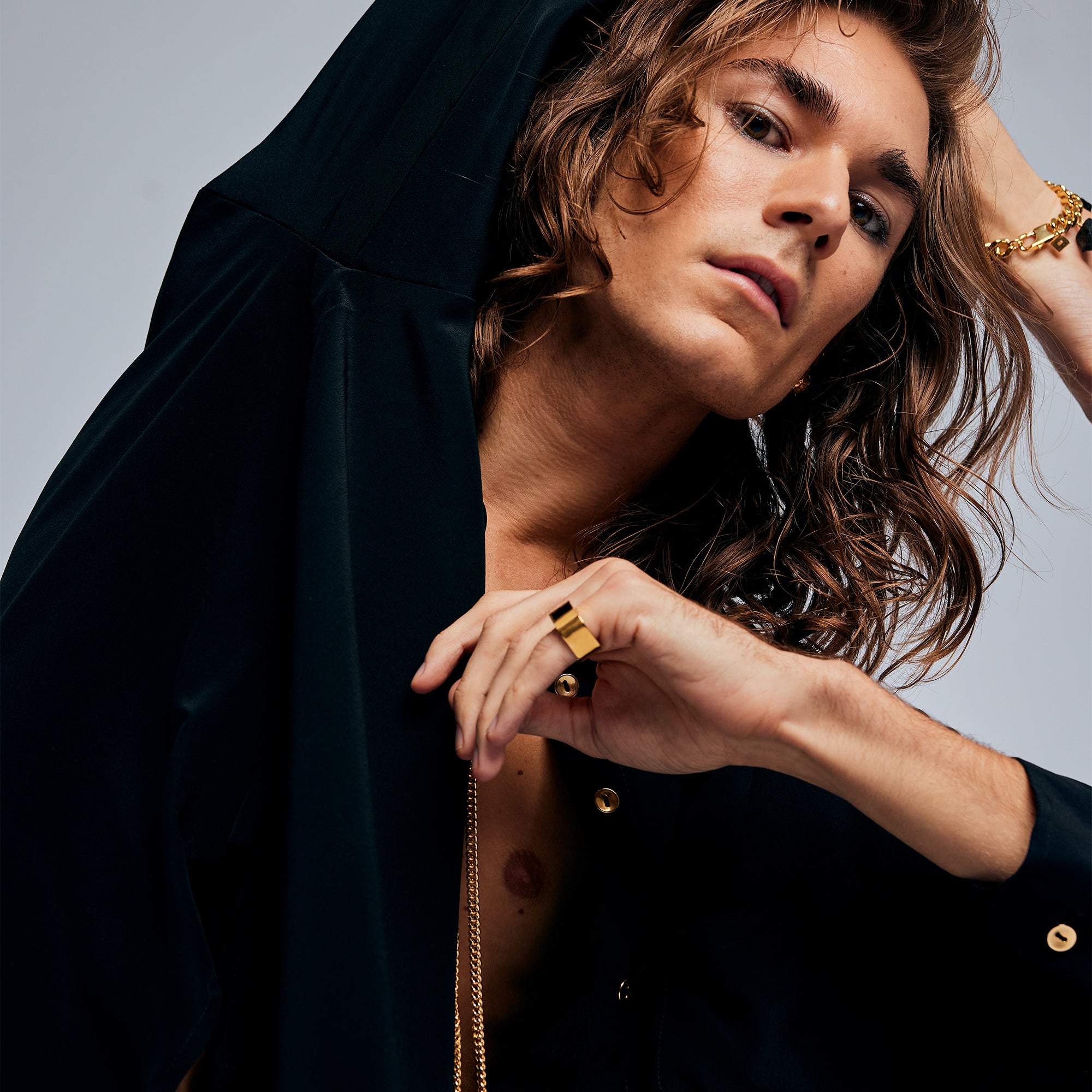 Side view of a male model wearing the Black Tourmaline Ring by Märta Larsson in gold vermeil. The brushed gold finish and geometric stone setting make this a standout tourmaline ring for fashion-forward styling.