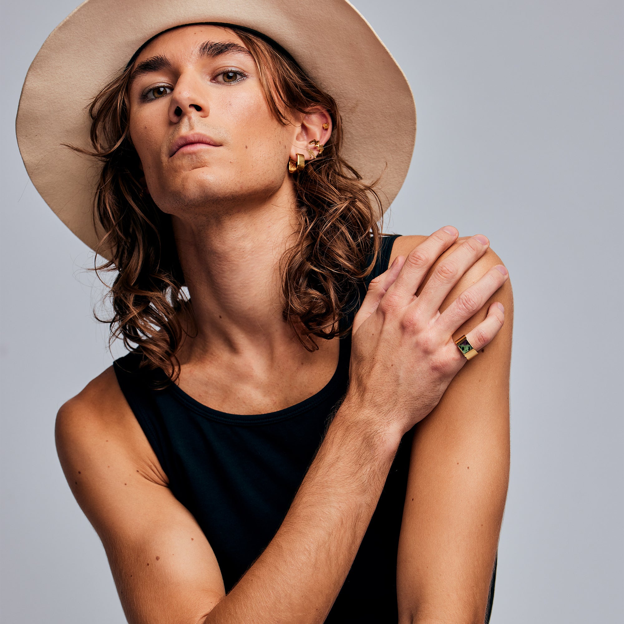Model in wide-brimmed hat wearing the Mondrian Ring Ruby Zoisite by Märta Larsson on the ring finger. Gold vermeil ring with natural stone, styled with bold accessories and confident pose.