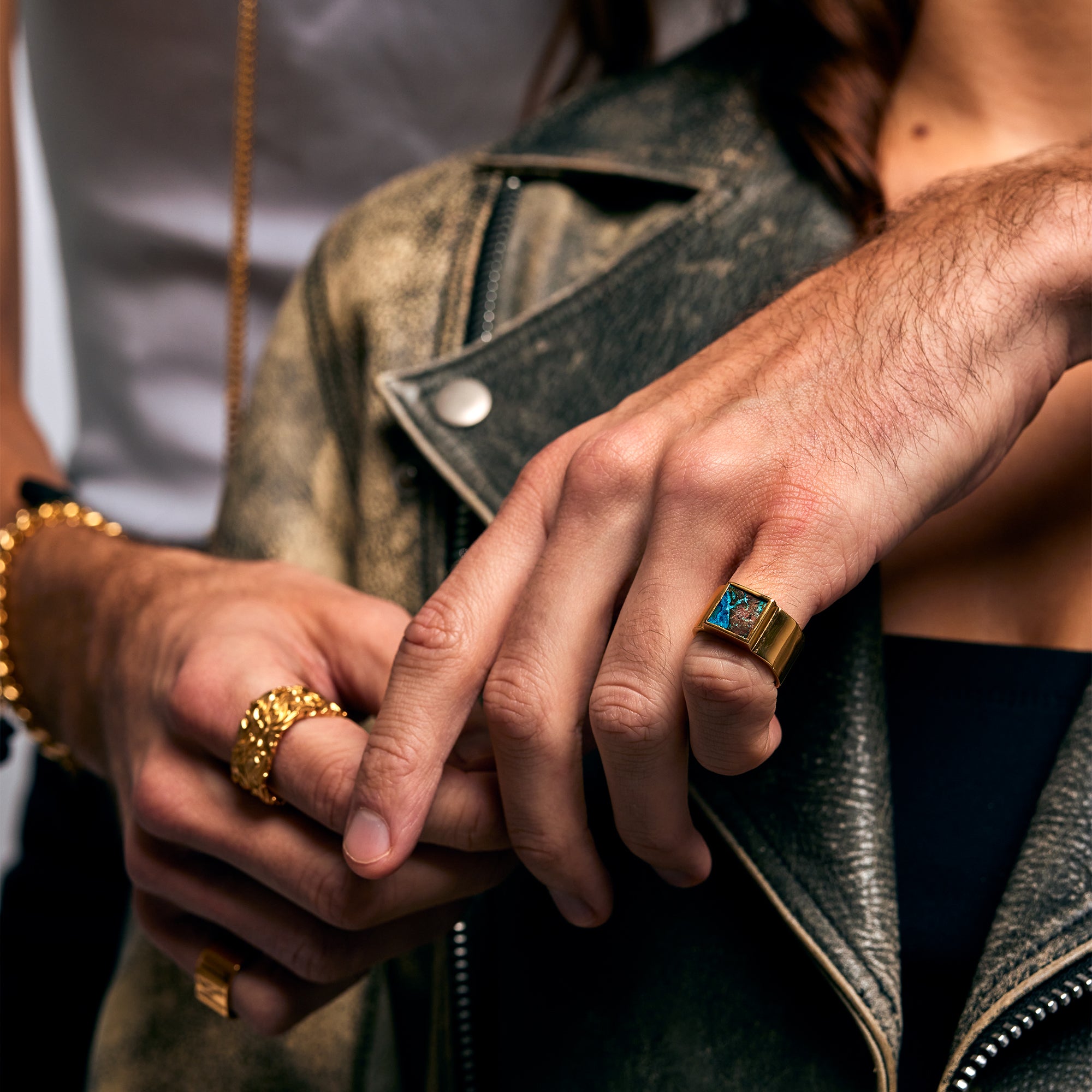 Male hands wearing the Shattuckite Signet Ring by Märta Larsson on the pinky finger. The brushed gold finish and geometric stone design make this gold vermeil ring a standout accessory for unisex styling and Swedish craftsmanship.