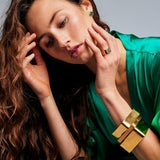 Female model with hands near her face wearing the Shattuckite Signet Ring by Märta Larsson on her ring finger. This designer crystal ring adds a refined touch to any outfit, perfect for fashion-forward styling and artistic expression.