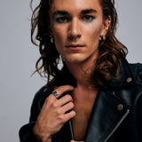 Male model posing with hand extended, wearing the Shattuckite Signet Ring by Märta Larsson on his index finger. This unisex statement ring blends rawness with elegance, ideal for styling with tailored fashion or casual looks.