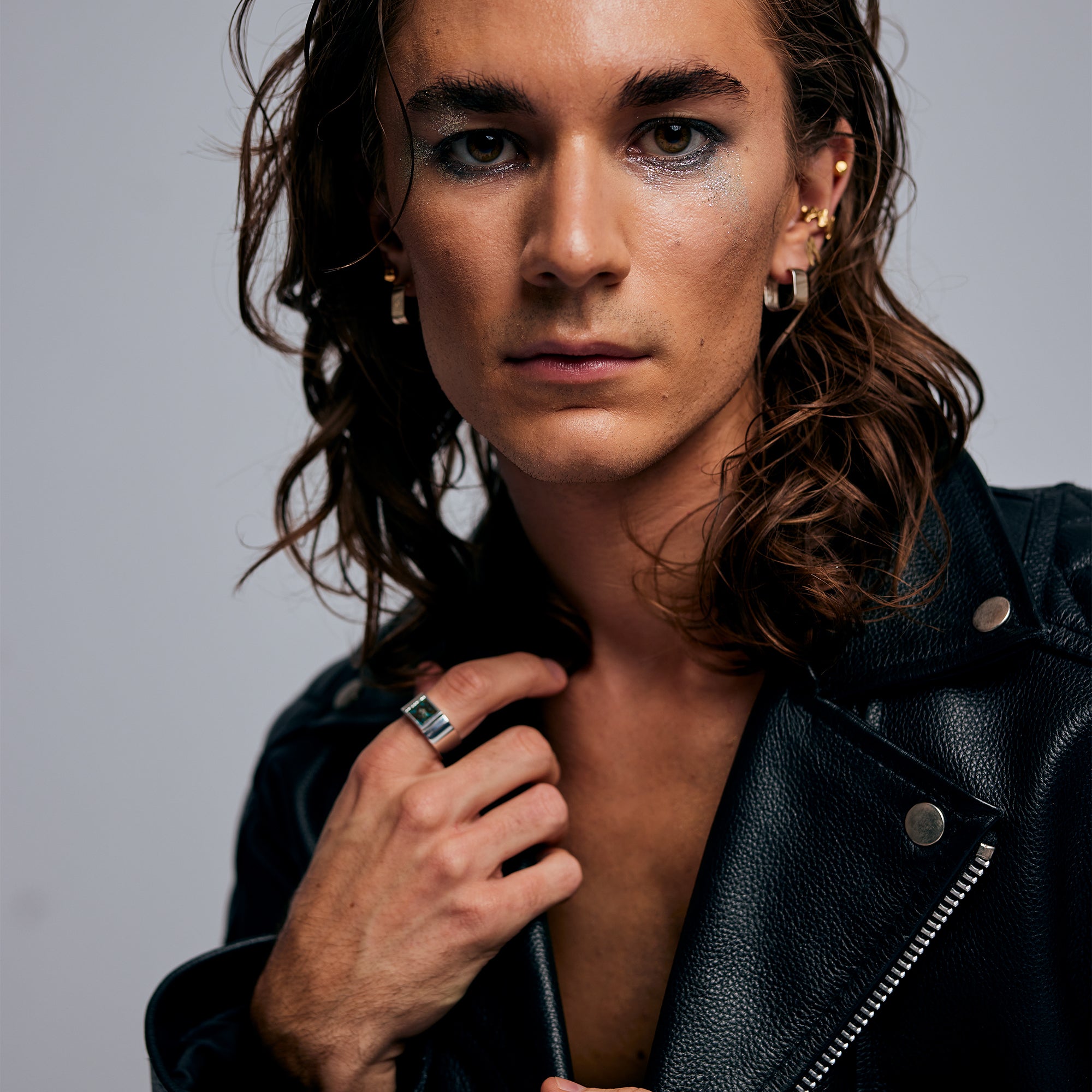 Male model posing with hand extended, wearing the Shattuckite Signet Ring by Märta Larsson on his index finger. This unisex statement ring blends rawness with elegance, ideal for styling with tailored fashion or casual looks.