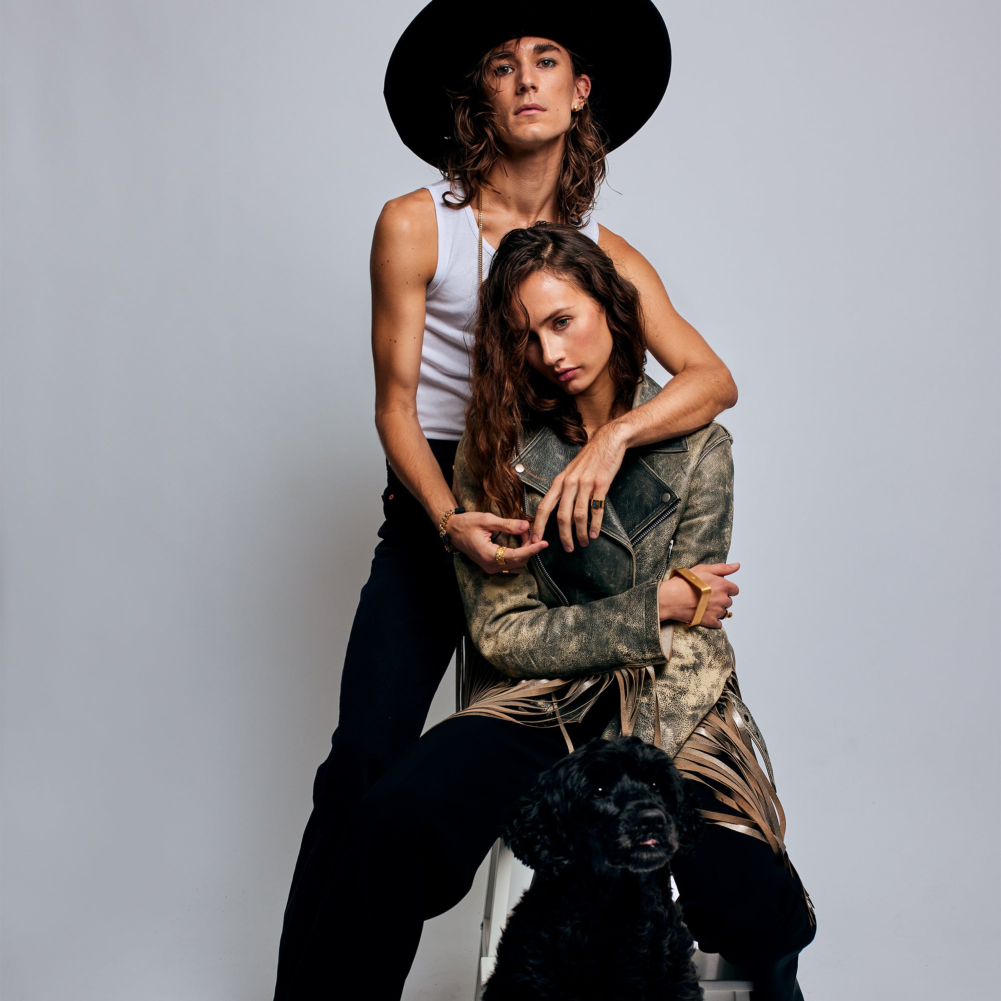 Two models embracing, with the male model wearing the Shattuckite Signet Ring by Märta Larsson on his pinky finger. This bold gemstone ring is a gender-neutral accessory that adds visual impact to any outfit.