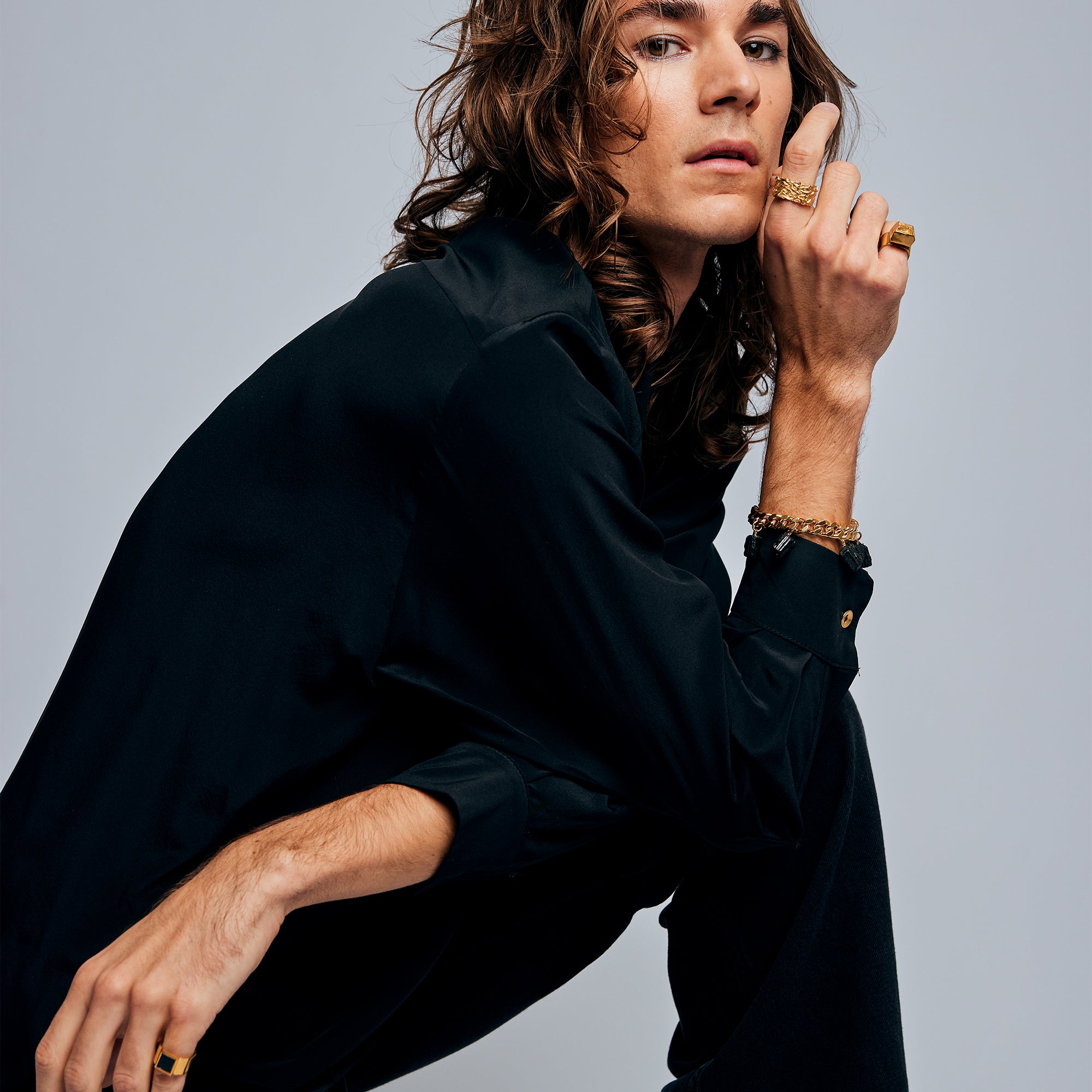 Male model posing, wearing Ring of Fire Gold by Märta Larsson on index finger. Statement gold ring with modern brutalist style.