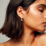 Model wearing Signature Creole Polished Silver Earrings by Märta Larsson with short hair and minimalist styling. Square silver hoops for bold, everyday wear.