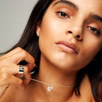 Model holding The Raw One Clear Quartz Necklace by Märta Larsson with silver ring. Clear quartz necklace styled for modern elegance and natural clarity.
