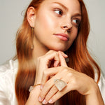 Model wearing Keep Me Hanging Rough Quartz Earrings by Märta Larsson with crystal bracelet and serene styling. Long quartz earrings styled for quiet strength and modern edge.