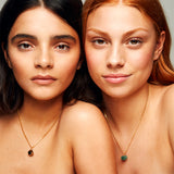 Model wearing The Raw One Rough Quartz Necklace by Märta Larsson with gold earring and raw quartz pendant. Clear quartz necklace styled for modern simplicity and subtle glow.