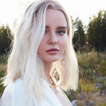 Outdoor portrait of elegant white silk kaftan dress by Märta Larsson, luxurious drape.