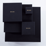 The Raw One Rough Quartz Earrings by Märta Larsson displayed in black branded packaging. Elegant box presentation for handcrafted crystal earrings and luxury accessories.