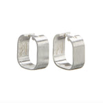 Signature Creole Brushed Silver Earrings by Märta Larsson shown open and closed. Modern hoop earrings with hinge clasp — sleek, functional, and sculptural.