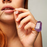 Model wearing Roxx Amethyst Ring by Märta Larsson on index finger. Raw amethyst ring styled with pink crystal necklace — expressive and artistic gemstone jewelry.