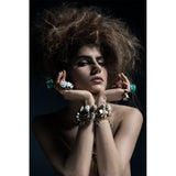 Model in dramatic pose wearing the Roxx Chrysocolla Ring by Märta Larsson. Statement ring styled with bold accessories and textured hair — wearable art with mineral elegance.