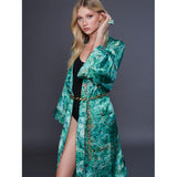 Model in green patterned robe wearing the Roxx Chrysocolla Ring by Märta Larsson. Nature-inspired fashion paired with raw stone jewelry — perfect for earthy luxury styling.