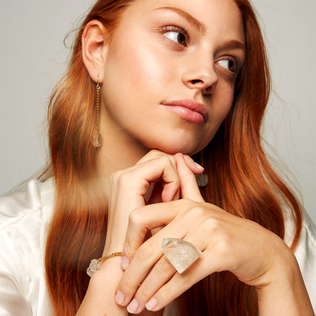 Model wearing Roxx Quartz Ring by Märta Larsson with matching crystal bracelet and earrings. Clear quartz ring styled for elegant, natural fashion.