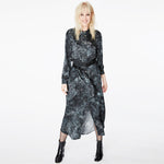 Model wearing the Glam Rock Silk Satin Shirt Dress by Märta Larsson, smiling and posing from the front. The relaxed silhouette and waist tie offer versatile styling, making this satin shirt dress a standout piece in luxury womens fashion.