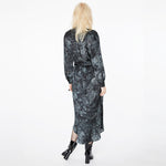 Back view of a model wearing the Glam Rock Silk Satin Shirt Dress by Märta Larsson. The dropped hem and back pleats create a sculptural silhouette, ideal for pairing with fashion accessories or styling as an elegant silk dress.