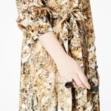 Close-up of the side of the Glam Rock Silk Satin Shirt Dress by Märta Larsson, showing the fabric’s pattern and model’s hand. The silk satin texture and subtle detailing highlight the elegance of this designer shirt dress, ideal for fashion-forward women.
