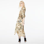 Side view of a model wearing the Glam Rock Silk Satin Shirt Dress by Märta Larsson. The shirt’s fluid drape and waist tie offer a flattering fit for all body shapes, making it a standout designer shirt dress in luxury womenswear.