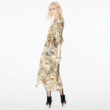 Side view of a model wearing the Glam Rock Silk Satin Shirt Dress by Märta Larsson. The shirt’s fluid drape and waist tie offer a flattering fit for all body shapes, making it a standout designer shirt dress in luxury womenswear.