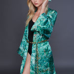 Model in green robe and black bodysuit wearing Gold Chain Belt & Necklace by Märta Larsson. Gold chain belt styled for expressive layering and editorial impact.