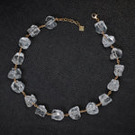 Not A Pearl Necklace Rough Quartz by Märta Larsson laid out on black textured surface. Gold necklace with raw quartz stones — handcrafted and sculptural.