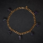 Collar Amethyst Bracelet by Märta Larsson laid out on black textured surface. Gold bracelet with raw amethyst charms — elegant, expressive, and naturally powerful.