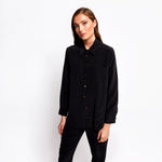 Model wearing the Boyfriend Silk Shirt by Märta Larsson, photographed from a slightly elevated angle against a white background. The shirt’s drop hem and silk satin finish add elegance to casual styling, ideal for pairing with mens luxury jewellery or mens signet rings.
