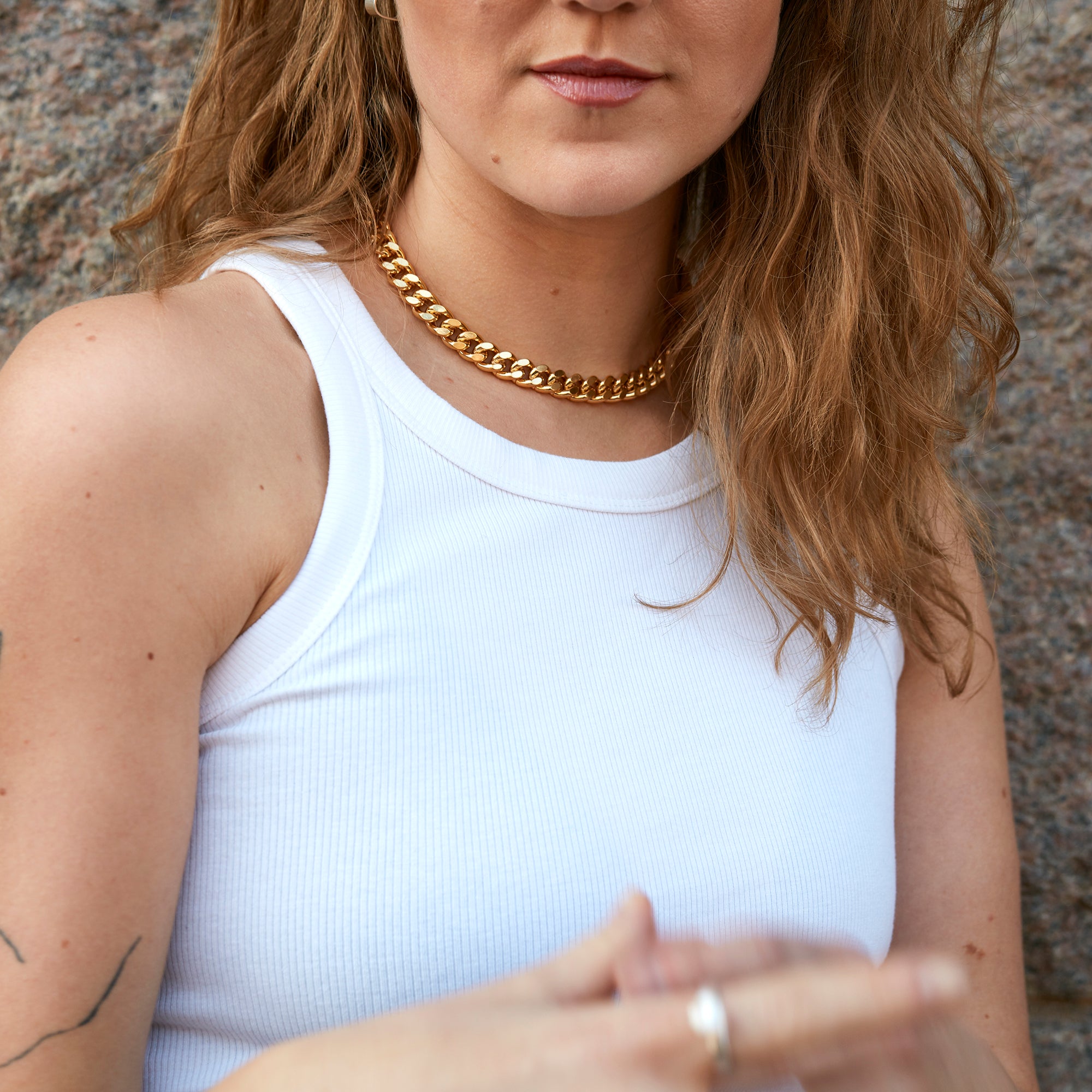 Model wearing handcrafted gold collar chain necklace by Märta Larsson with white ribbed tank top.