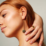 Model brushing hair from her neck wearing the Signature Gold Vermeil Ring by Märta Larsson on the pinky, a minimalist polished gold-vermeil accent.