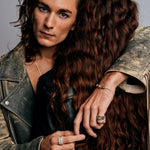 Two individuals embracing, one wearing the Mondrian Ring Dalmatian by Märta Larsson. Textured fashion styling with silver jewelry and intimate composition.