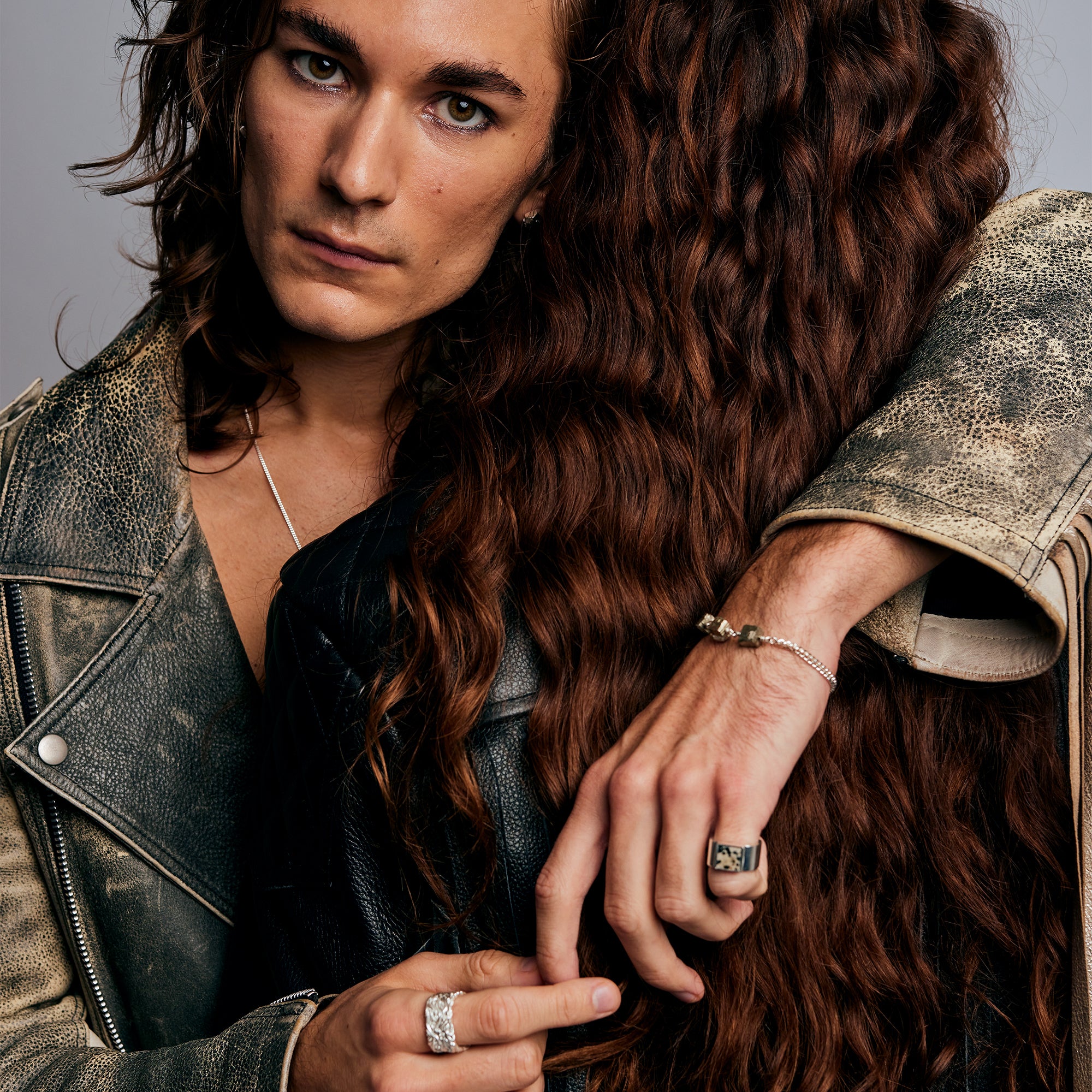Two individuals embracing, one wearing the Mondrian Ring Dalmatian by Märta Larsson. Textured fashion styling with silver jewelry and intimate composition.