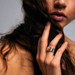 Close-up of a person holding their hair wearing the Mondrian Ring Garnet in Limestone by Märta Larsson on the middle finger, an artistic gold-vermeil gemstone ring with earthy stone detail.