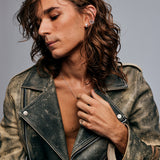Model in open leather jacket with silver necklace wearing the Mondrian Ring Garnet in Limestone by Märta Larsson, a bold geometric ring styled with layered accessories.