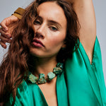 Model in green satin blouse wearing the Not A Pearl Necklace Chrysocolla by Märta Larsson, a raw chrysocolla statement piece radiating vibrant energy.