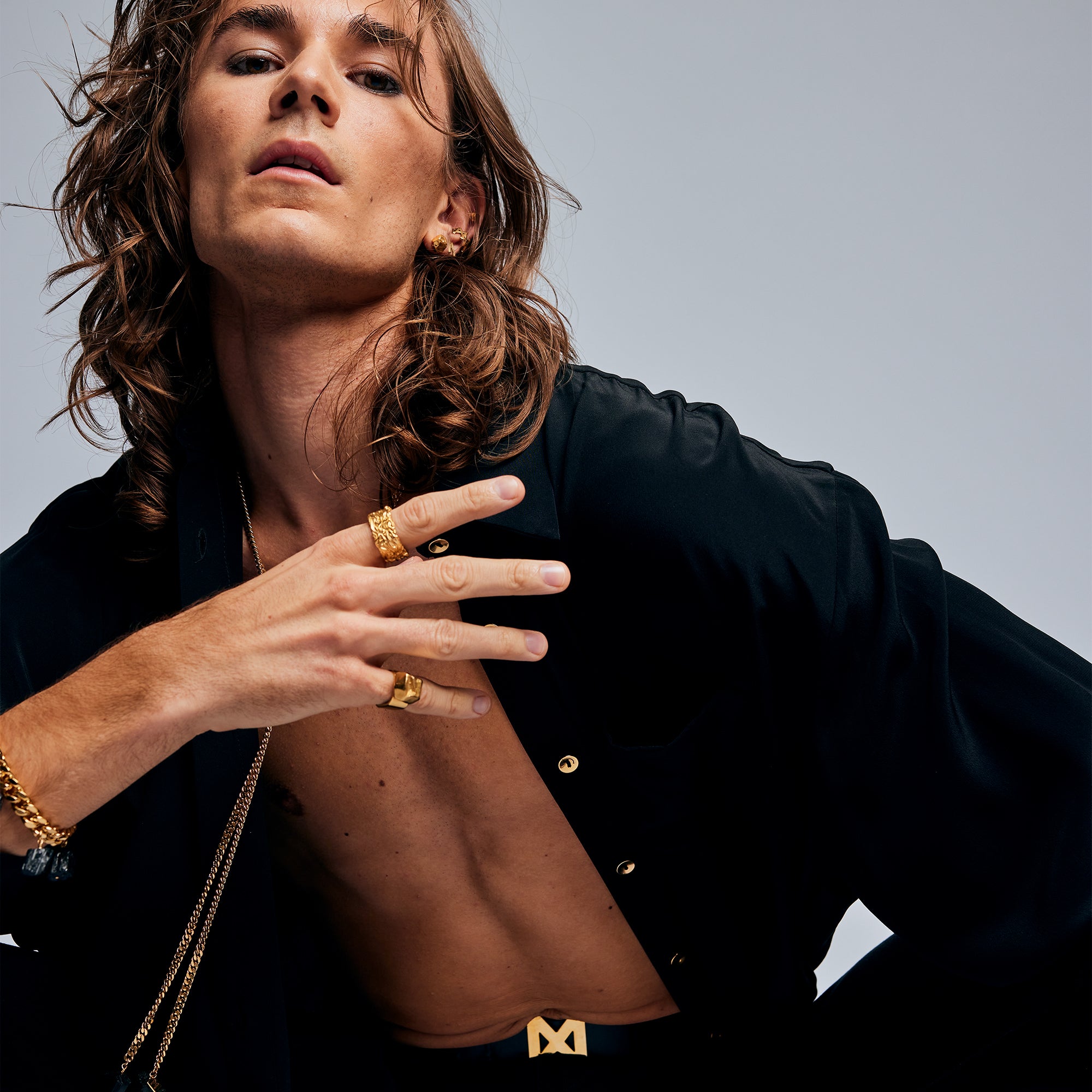 Male model wearing The Power Ring by Märta Larsson in gold vermeil on his pinky finger, featuring a raw crystal and bold wide band with brutalist modern style.
