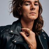 Male model in leather jacket wearing the Ring of Fire Gold by Märta Larsson on the index finger, a rock-inspired gold-vermeil ring with sculptural edge.