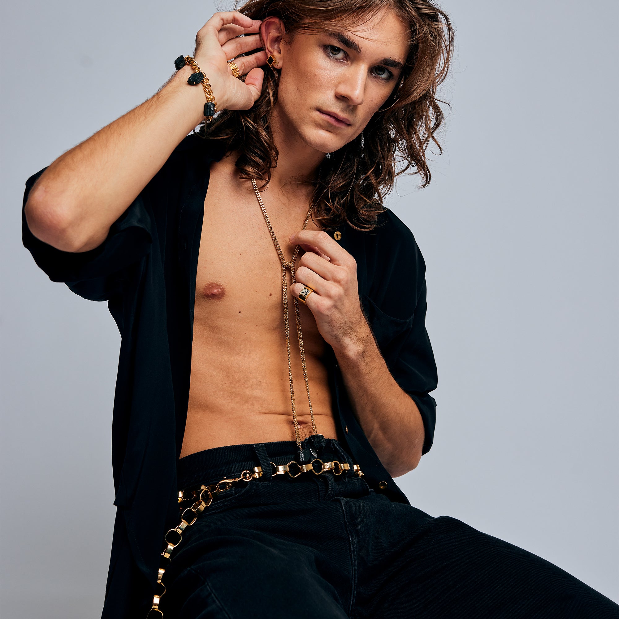 Model in black shirt and pants wearing the Gold Chain Belt & Necklace by Märta Larsson, a convertible polished gold chain styled for modern, expressive fashion.