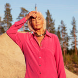 Model outdoors scratching her forehead wearing the Signature Silver Ring by Märta Larsson on her pinky finger, featuring a polished sculptural minimalist silver band.