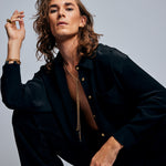 Model wearing the Tie Me Up Black Tourmaline Necklace by Märta Larsson, a raw tourmaline lariat styled with layered gold jewelry for confident elegance.