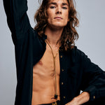 Model in black shirt wearing the Tie Me Up Black Tourmaline Necklace by Märta Larsson, a raw tourmaline lariat styled for modern power dressing.