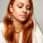 Model wearing the Collar Rough Quartz Necklace by Märta Larsson with a white satin blouse, a raw clear quartz piece styled for minimalist effortless impact.