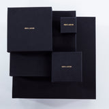 Luxury packaging for Märta Larsson jewelry, black boxes with gold branding designed for pyrite rings and crystal accessories.      