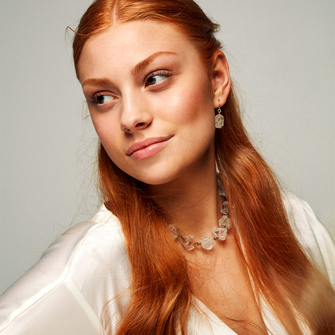 Model wearing the Not a Pearl Necklace Rough Quartz by Märta Larsson with a silky blouse and drop earrings, styled for confident natural elegance.